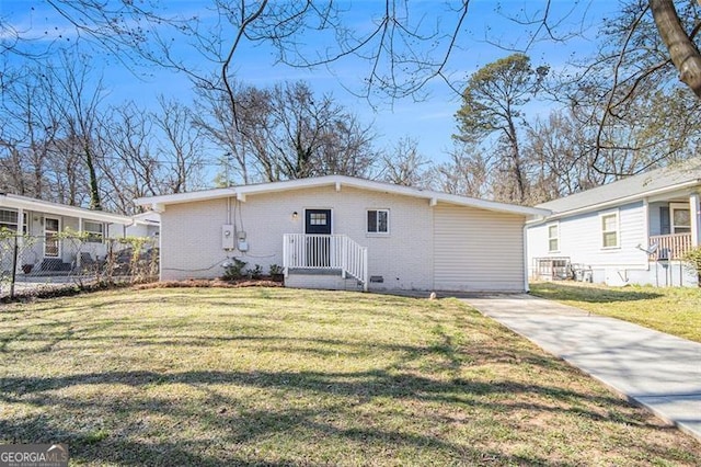 view of front of home with concrete driveway, a front lawn, fence, and brick siding