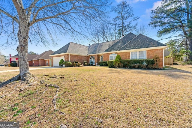 ranch-style home featuring a garage, brick siding, a front lawn, and a shingled roof