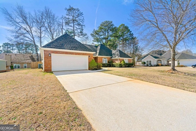 view of front of home featuring driveway, a shingled roof, an attached garage, a front lawn, and brick siding