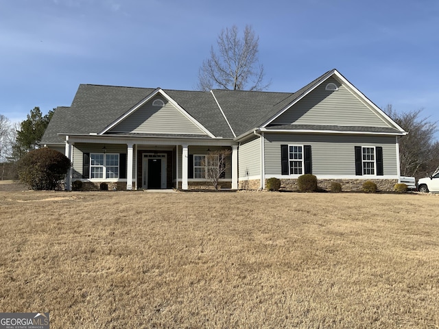 view of front of property featuring a shingled roof, a porch, and a front lawn