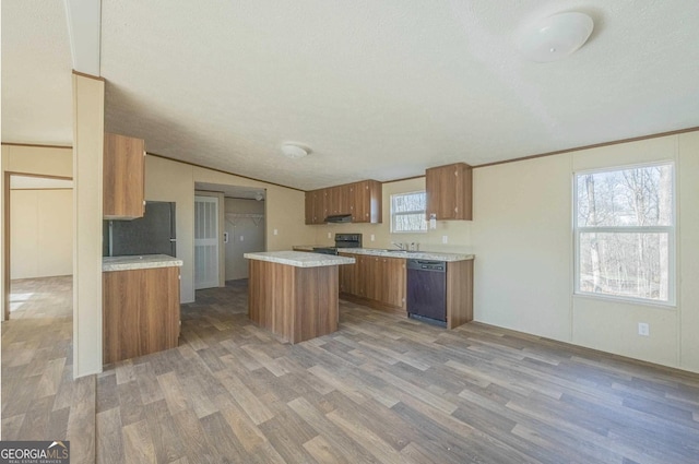 kitchen with light countertops, brown cabinets, light wood-style flooring, and black appliances