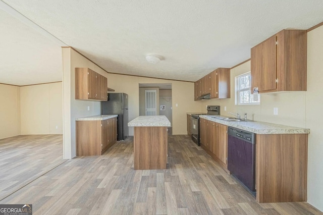 kitchen with brown cabinets, light countertops, light wood-type flooring, black appliances, and a sink