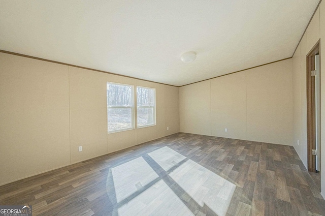 spare room featuring ornamental molding and wood finished floors