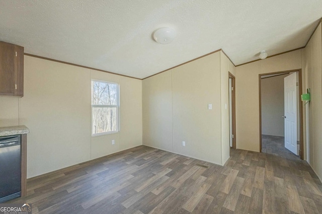 interior space with lofted ceiling, crown molding, a textured ceiling, and wood finished floors