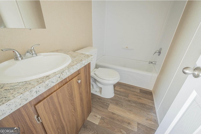 bathroom featuring toilet, shower / bathtub combination, wood finished floors, and vanity