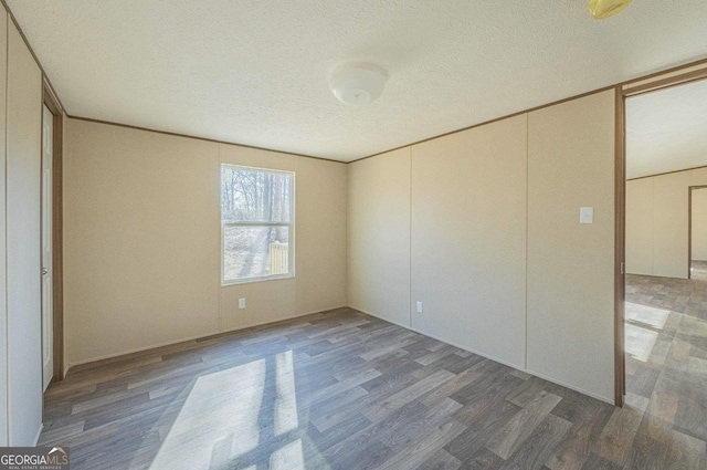 unfurnished bedroom with a textured ceiling and wood finished floors