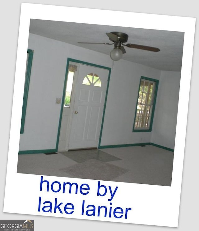 foyer entrance featuring ceiling fan and baseboards