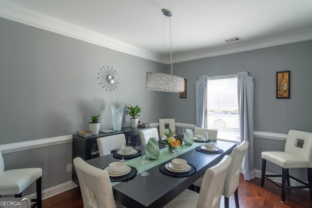 dining space featuring baseboards, crown molding, visible vents, and wood finished floors