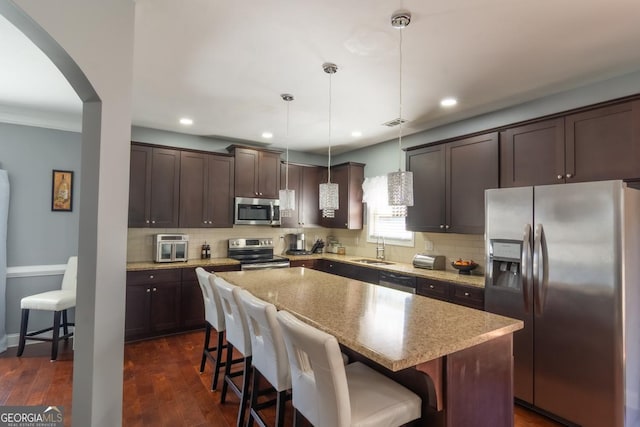 kitchen featuring appliances with stainless steel finishes, dark wood-type flooring, a sink, and dark brown cabinets