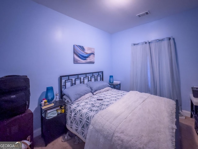 carpeted bedroom featuring visible vents