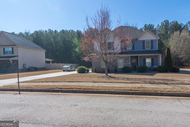 view of front facade featuring cooling unit, concrete driveway, and fence