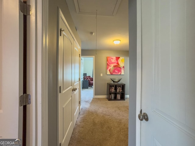 corridor featuring carpet floors, attic access, and baseboards