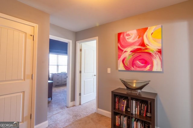 hall with baseboards and carpet flooring