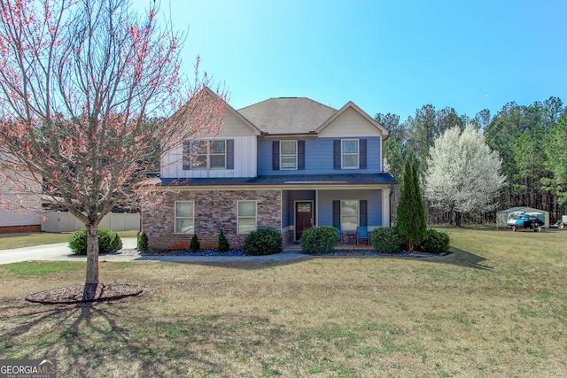 traditional-style home featuring brick siding, board and batten siding, a front lawn, fence, and a porch