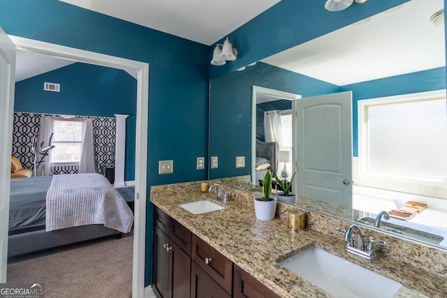 bathroom featuring a sink, double vanity, and ensuite bath