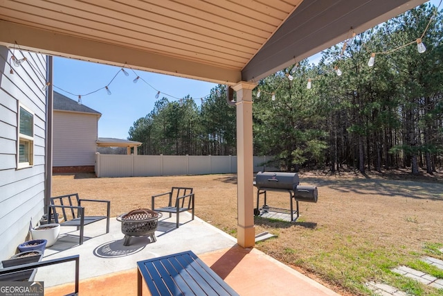 view of patio featuring fence, a fire pit, and grilling area