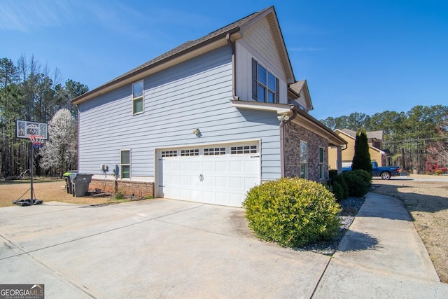 view of property exterior featuring concrete driveway, stone siding, an attached garage, and brick siding