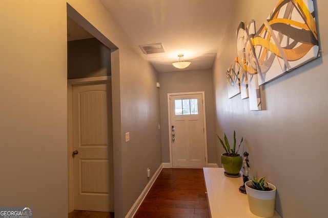 doorway to outside with dark wood-style floors, baseboards, and visible vents