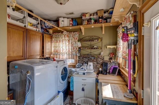 clothes washing area featuring cabinet space and washer and dryer