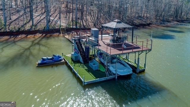 dock area with a water view, boat lift, and a gazebo