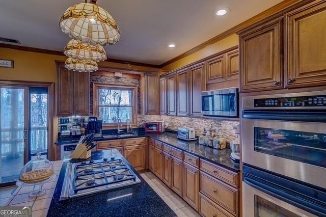 kitchen with light tile patterned floors, decorative backsplash, stainless steel appliances, crown molding, and a sink