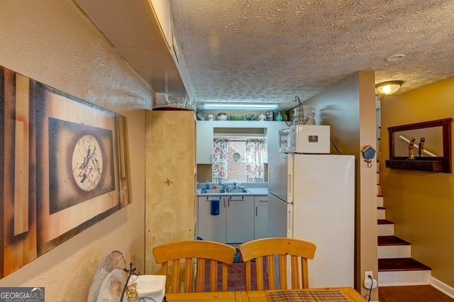 dining space with stairs, baseboards, and a textured ceiling