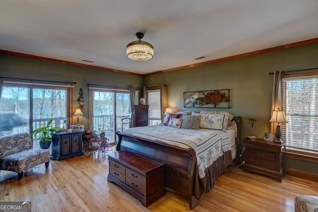 bedroom featuring access to outside, ornamental molding, visible vents, and light wood-style floors