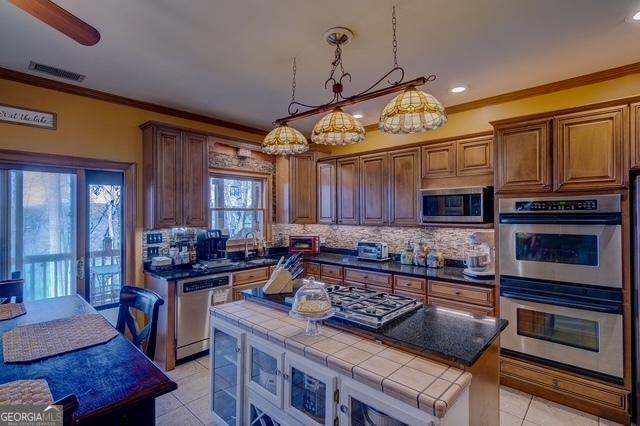 kitchen featuring visible vents, appliances with stainless steel finishes, decorative backsplash, and crown molding