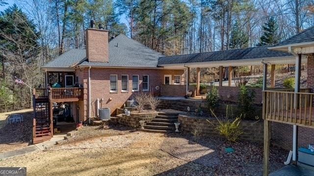 back of house with a chimney, stairway, and cooling unit