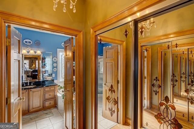 bathroom with a notable chandelier, vanity, and tile patterned floors