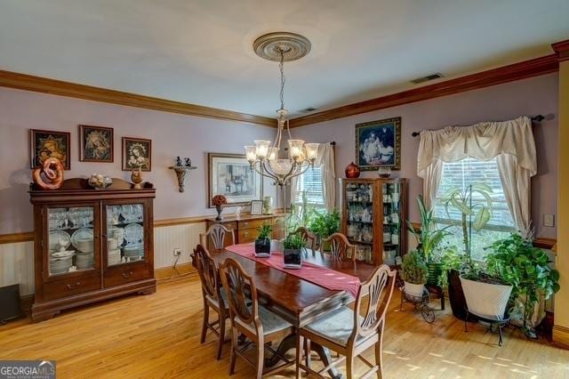 dining room featuring plenty of natural light, visible vents, light wood-style flooring, and wainscoting