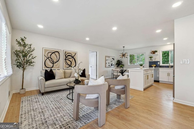 living area with baseboards, recessed lighting, and light wood-style floors