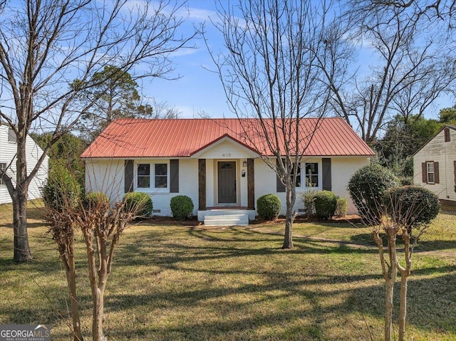 view of front of house featuring crawl space, a front lawn, metal roof, and brick siding