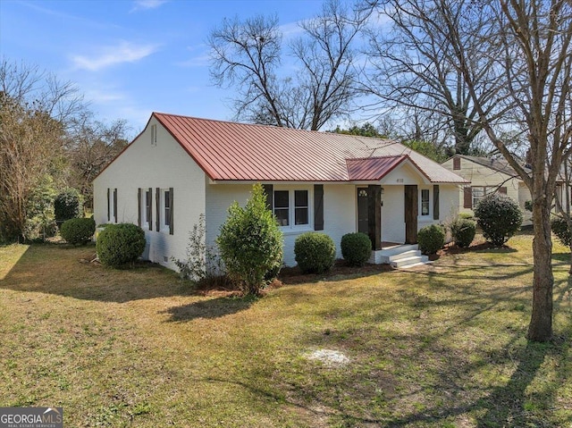 ranch-style house with metal roof, brick siding, and a front yard