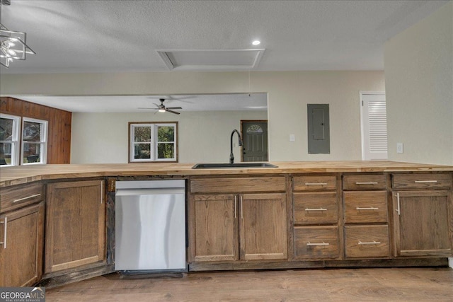 kitchen with stainless steel dishwasher, butcher block counters, electric panel, and a sink