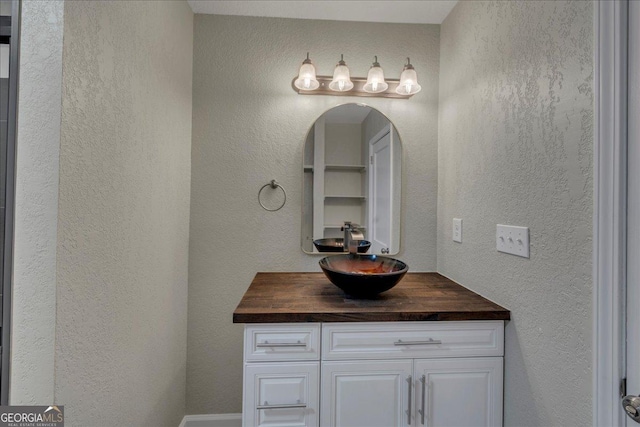 bathroom featuring a textured wall and vanity