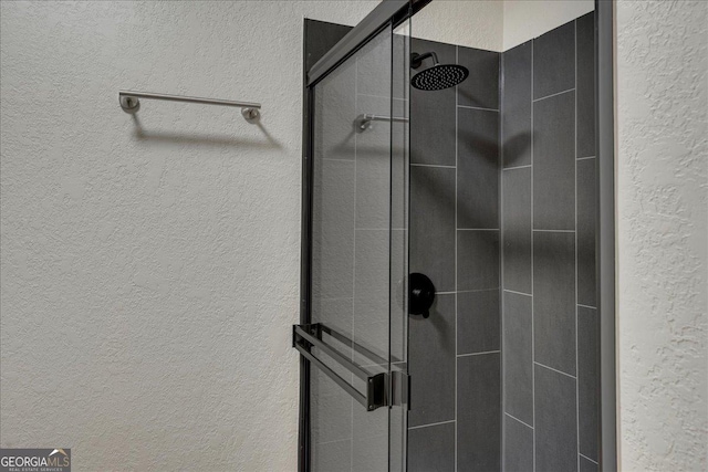 interior space featuring a textured wall and a shower stall