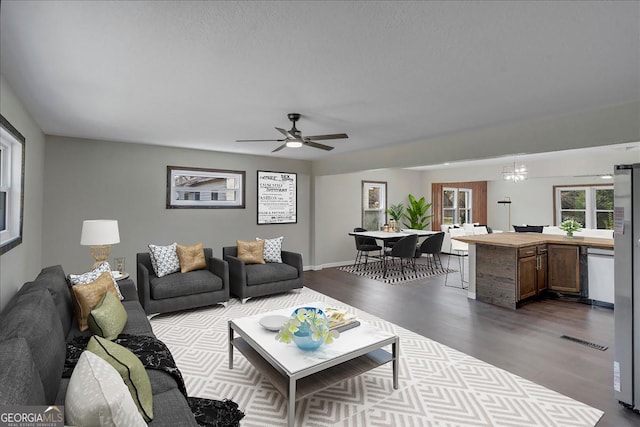 living room with ceiling fan, dark wood-style flooring, and visible vents