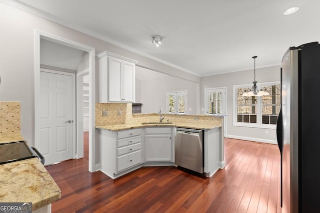 kitchen featuring tasteful backsplash, appliances with stainless steel finishes, white cabinetry, a sink, and a peninsula