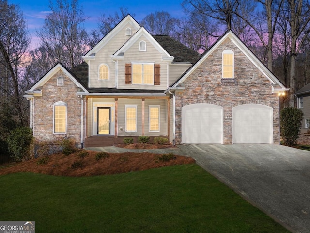 view of front of house with a yard, aphalt driveway, and an attached garage