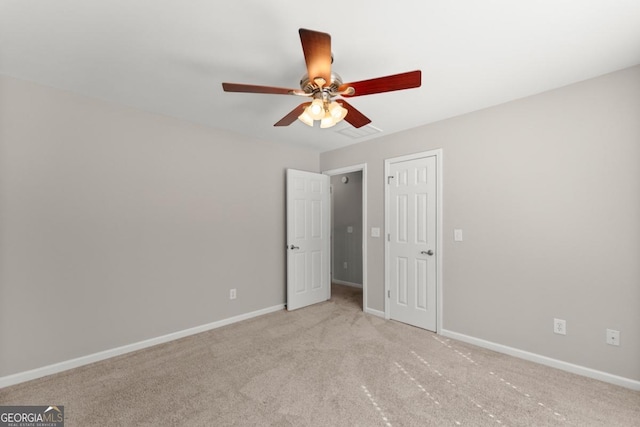 unfurnished bedroom featuring carpet, visible vents, baseboards, and a ceiling fan