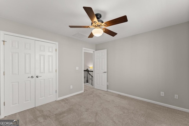 unfurnished bedroom featuring carpet, a closet, visible vents, ceiling fan, and baseboards