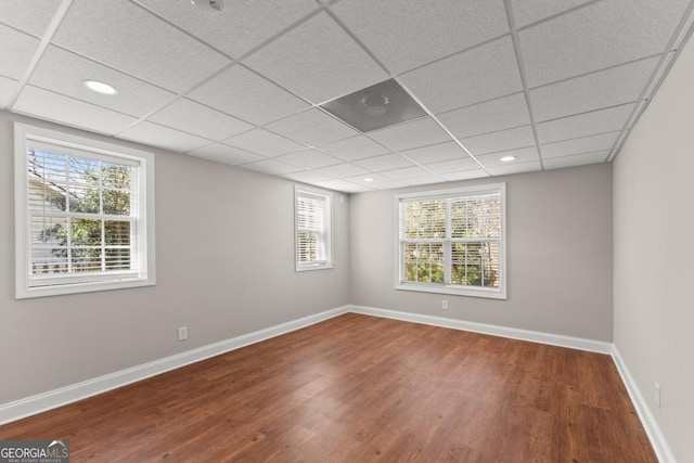 unfurnished room with baseboards, a drop ceiling, wood finished floors, and recessed lighting