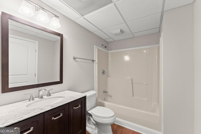 full bath with visible vents, bathing tub / shower combination, toilet, vanity, and a paneled ceiling