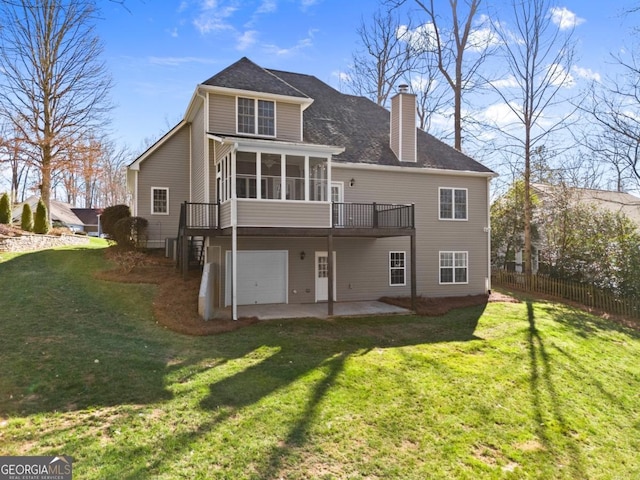 rear view of property featuring driveway, a sunroom, a chimney, fence, and a patio area