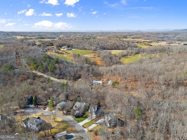 drone / aerial view with a wooded view