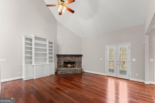 unfurnished living room featuring high vaulted ceiling, baseboards, a stone fireplace, and hardwood / wood-style floors