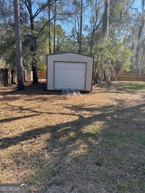 garage with fence and a shed