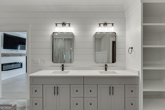 bathroom featuring double vanity, walk in shower, and a sink