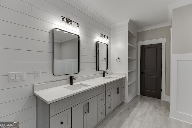 full bath featuring double vanity, crown molding, and a sink